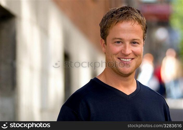Portrait of young smiling man outdoors.