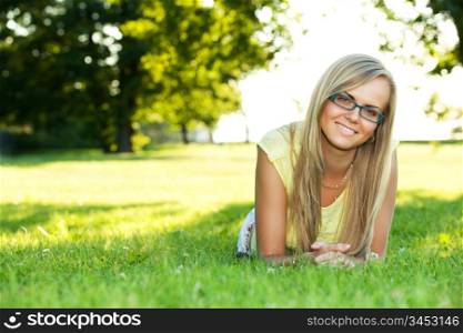 portrait of young smiling woman in the summer park