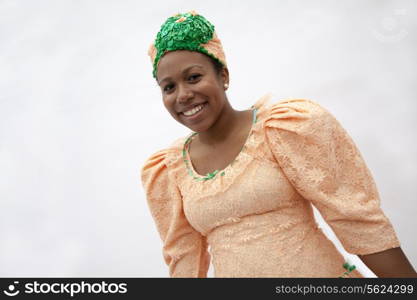 Portrait of young smiling woman in traditional clothing from the Caribbean, studio shot