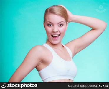 Portrait of young sporty happy woman fit fitness blond girl on turquoise. Sport training. Studio shot.