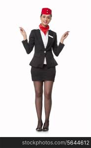 Portrait of young stewardess indicating exits isolated over white background