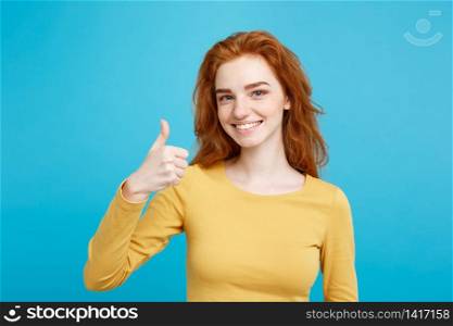 Portrait of young stylish freckled girl laughing with showing thumps up at camera. Copy space.