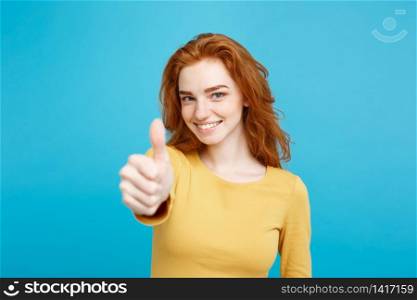 Portrait of young stylish freckled girl laughing with showing thumps up at camera. Copy space.