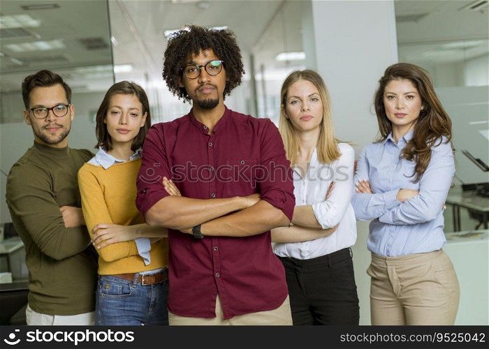 Portrait of young successful creative business team looking at camera and smiling in the office