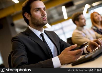 Portrait of young successful serious bearded businessman working on computer sitting in office