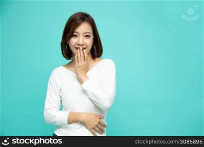 Portrait of young surprised woman isolated on green background, Oops concept, Asian model