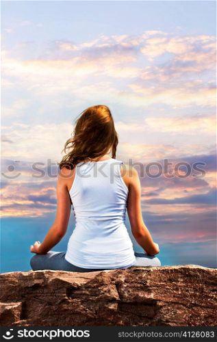 Portrait of young teenage girl practicing yoga at sunset