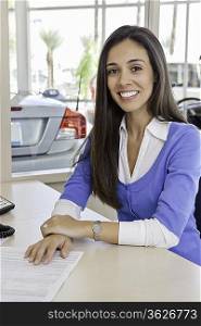 Portrait of young woman at car showroom