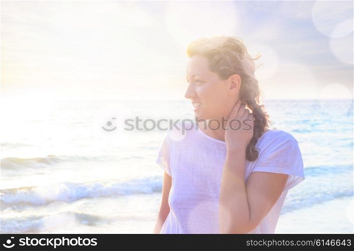 Portrait of young woman at the beach. Closeup portrait of young smiling caucasian woman at the beach