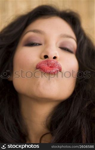 Portrait of young woman blowing kisses