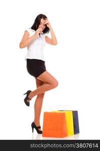 Portrait of young woman carrying shopping bags against white background