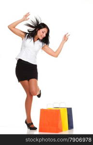 Portrait of young woman carrying shopping bags against white background