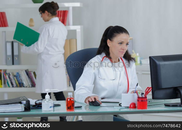 portrait of young woman doctor in white coat at computer