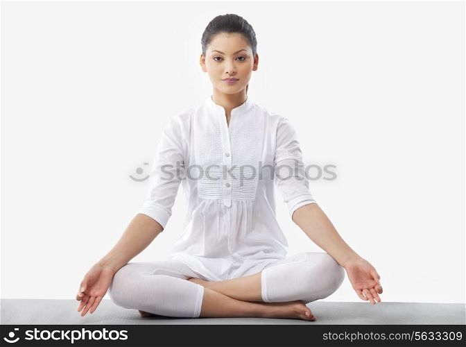 Portrait of young woman doing yoga over white background