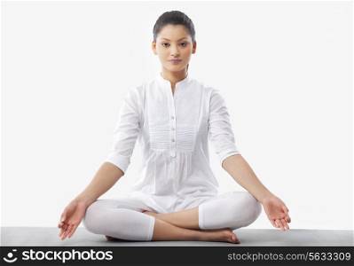 Portrait of young woman doing yoga over white background