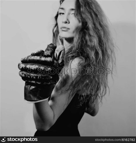 Portrait of young woman dressed in evening dress and boxing gloves