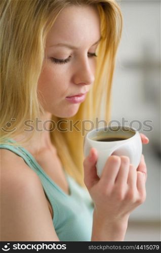 Portrait of young woman drinking coffee in the morning
