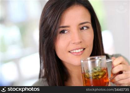 Portrait of young woman drinking herbal infusion