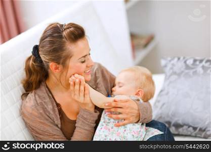 Portrait of young woman enjoying being mothers with baby on hands &#xA;