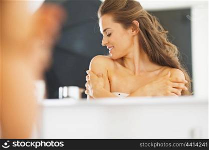 Portrait of young woman in bathroom happy with her skin condition