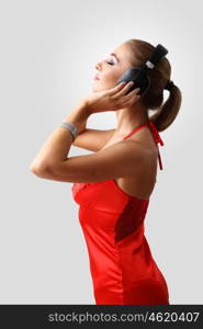 Portrait of young woman in evening dress with headphones