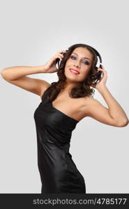 Portrait of young woman in evening dress with headphones