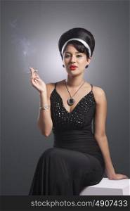 Portrait of young woman in evening gown smoking