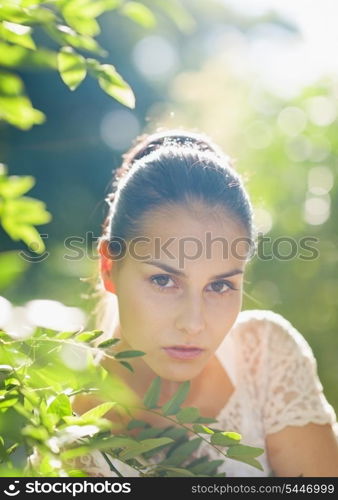 Portrait of young woman in foliage