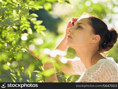 Portrait of young woman in foliage looking on copy space