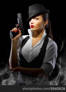 Portrait of young woman in manly style with gun and smoke
