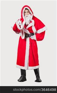 Portrait of young woman in Santa costume gesturing against gray background