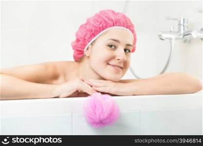 Portrait of young woman in shower cap posing in bath