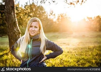 Portrait of young woman in sunlit park