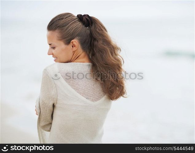 Portrait of young woman in sweater on lonely beach