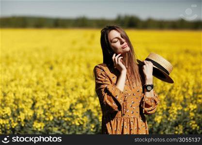 Portrait of young woman in the field of yellow flowers. summer happiness concept, beautiful girl.. Portrait of young woman in the field of yellow flowers. summer happiness concept, beautiful girl