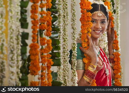 Portrait of young woman in traditional wear standing near garlands