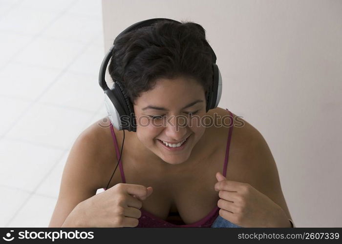 Portrait of young woman listening to music and snapping fingers