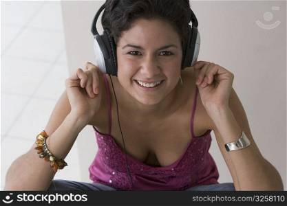 Portrait of young woman listening to music and snapping fingers
