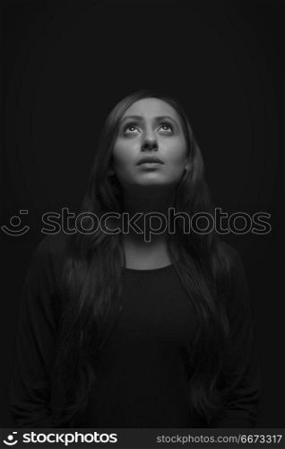 Portrait of young woman looking up