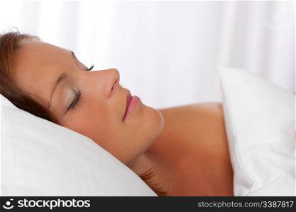 Portrait of young woman lying in bed, sleeping