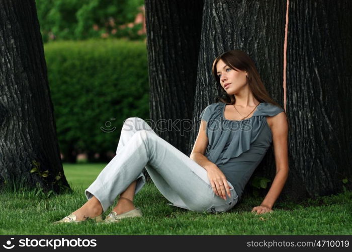 Portrait of young woman lying on a green lawn