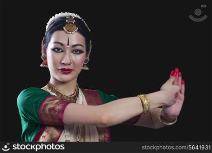 Portrait of young woman making Bharatanatyam gesture called Shankha on black background