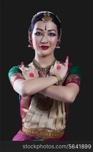 Portrait of young woman making Bharatanatyam gesture called Utsangam on black background
