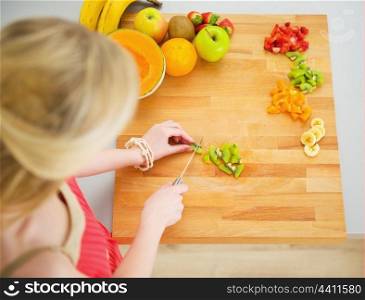 Portrait of young woman making fruits salad