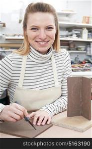 Portrait Of Young Woman Making Pot in Ceramics Studio