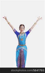 Portrait of young woman performing Bharatanatyam over white background