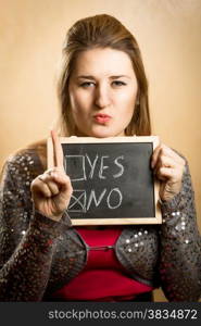 Portrait of young woman showing checked box with answer