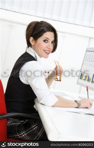 Portrait of young woman sitting at desk in office