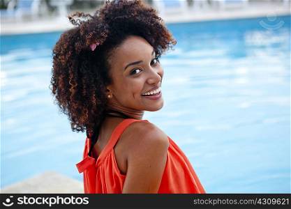 Portrait of young woman sitting at hotel poolside, Rio De Janeiro, Brazil