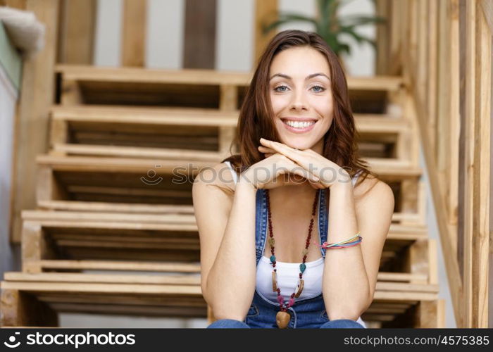 Portrait of young woman sitting at the stairs in office. Portrait of young woman wearing casual clothes sitting at the stairs in office